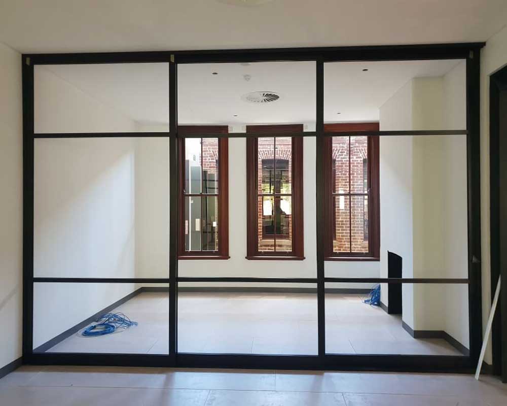 Full-width black framed glass partition